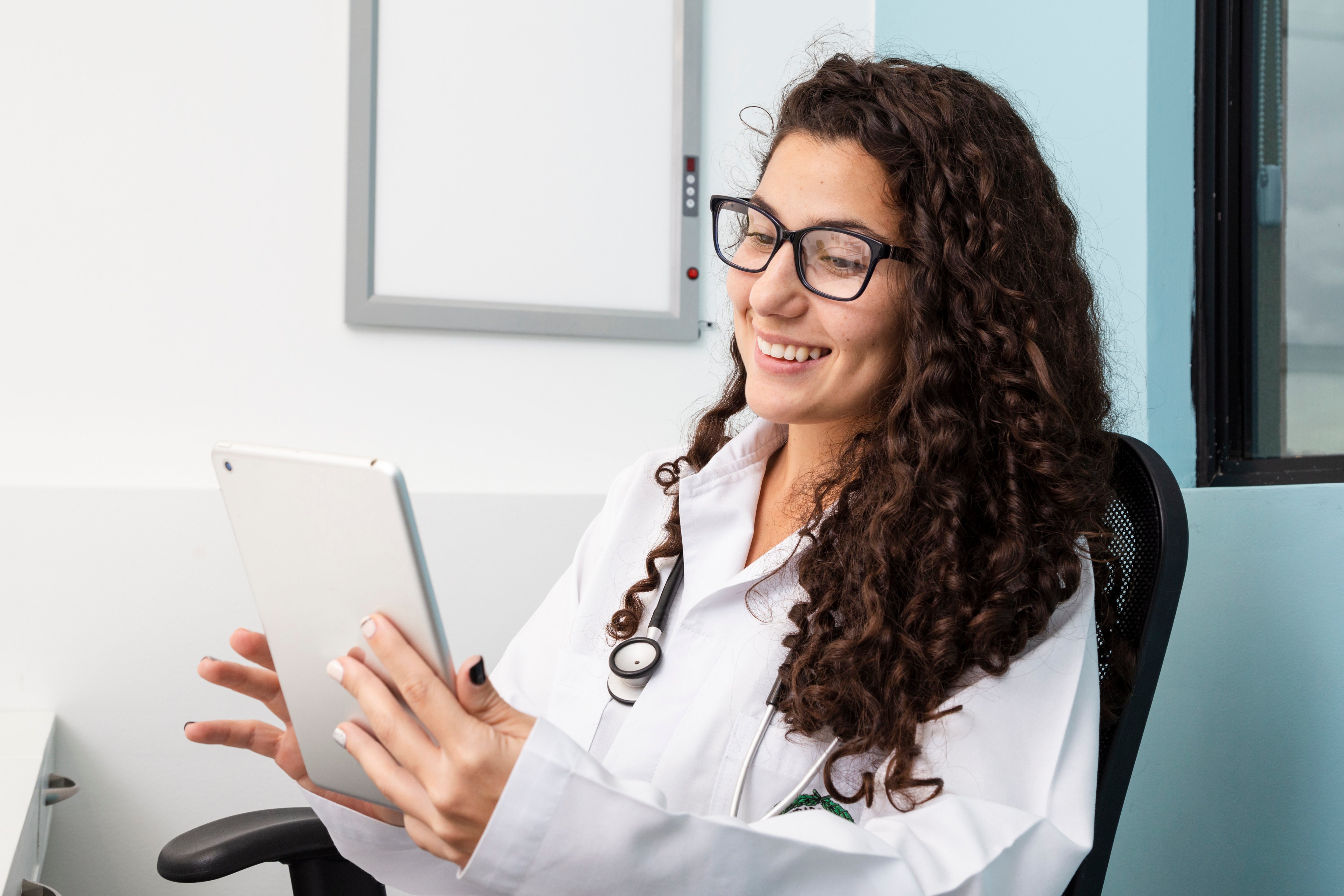 medium-shot-doctor-checking-her-tablet